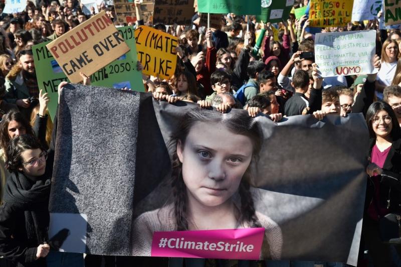 Personas y estudiantes sostienen carteles y pancartas que muestran a la activista política sueca Greta Thunberg, de 16 años, en protesta contra el calentamiento global en el centro de Roma, el 15 de marzo de 2019. Andreas SOLARO / AFP
